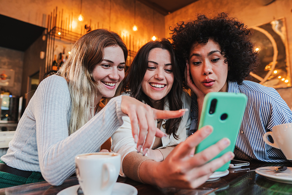 Three girls are watching the mobile phone